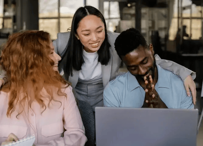 Three comfortable and happy people working on a project together in front of a computer